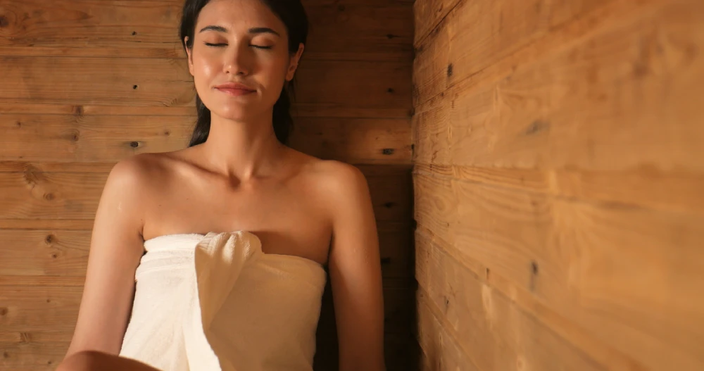 young woman in an infrared sauna with her eyes closed